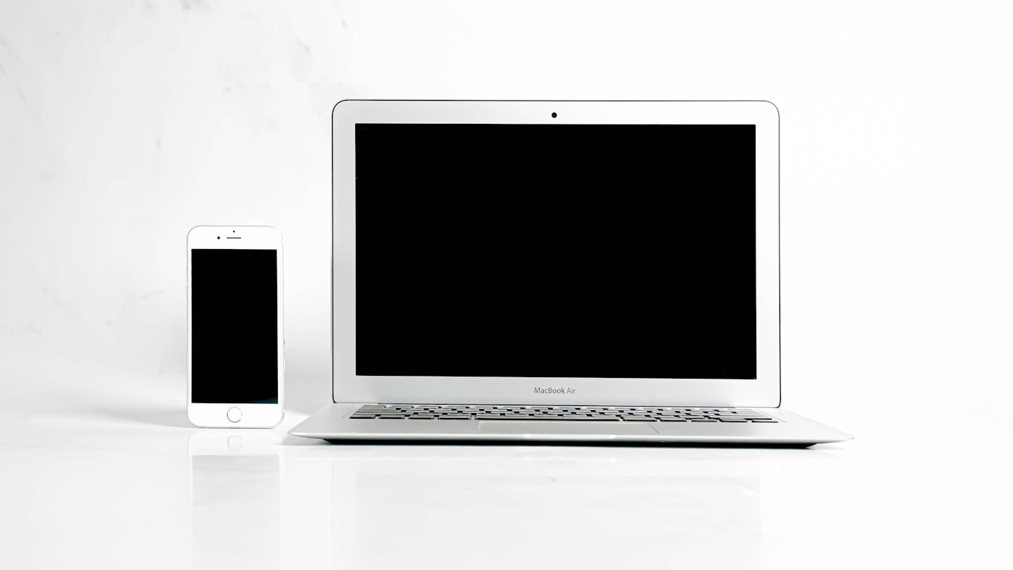 Phone and laptop on a desk representing paid messaging and platform billing