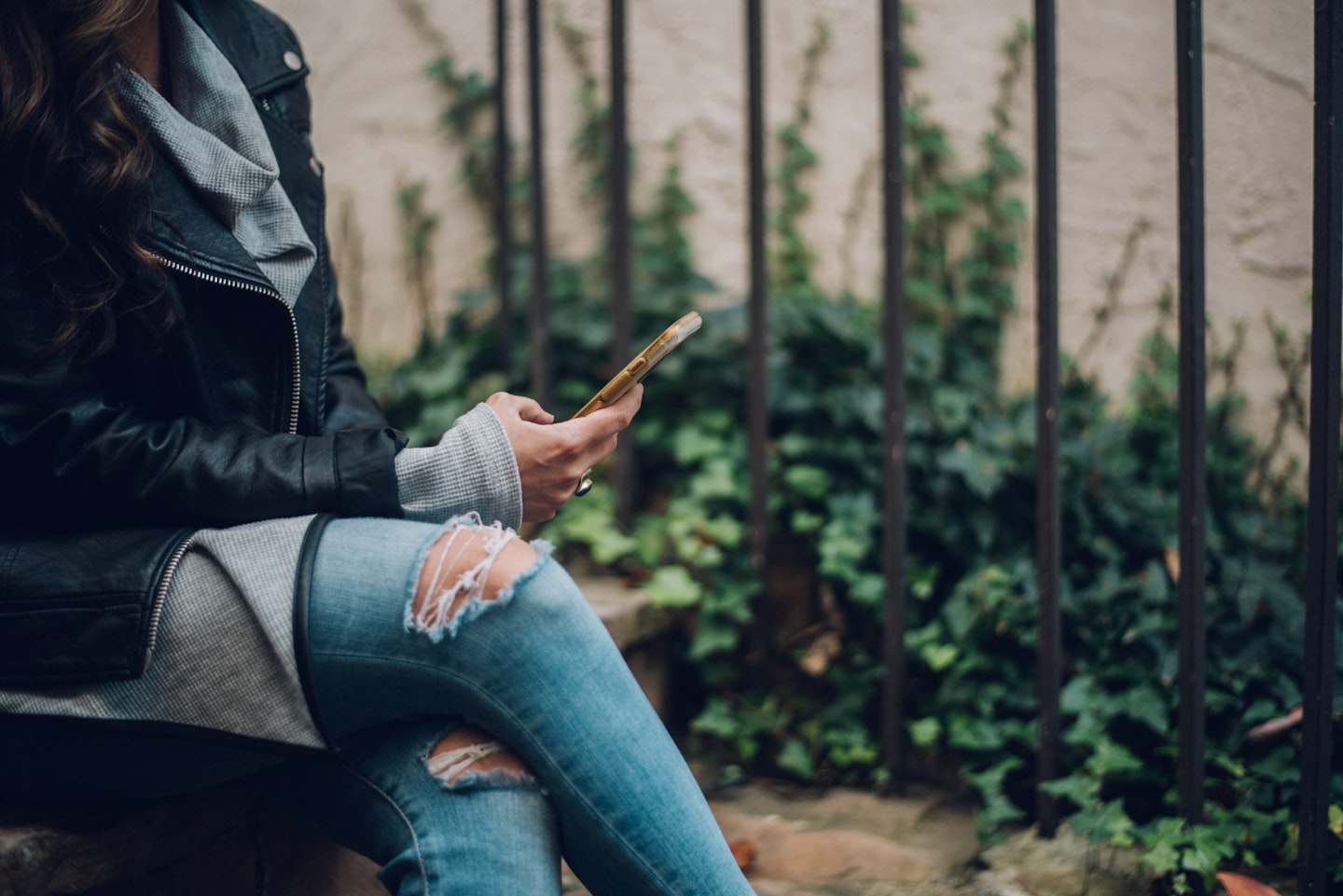 A woman browsing creator content on a smartphone, illustrating audience behavior and subscription interest.