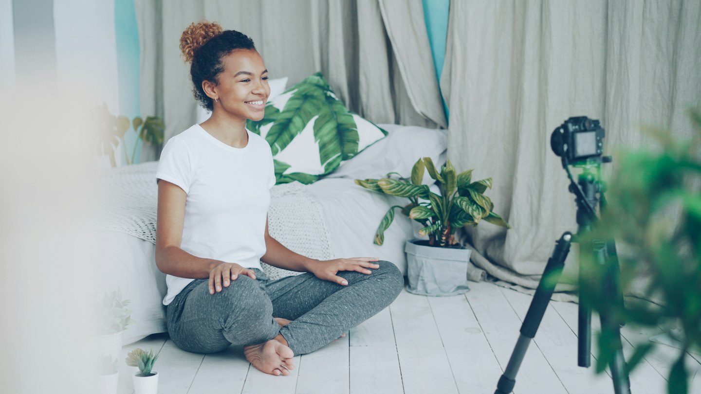 A woman records herself with a camera at home