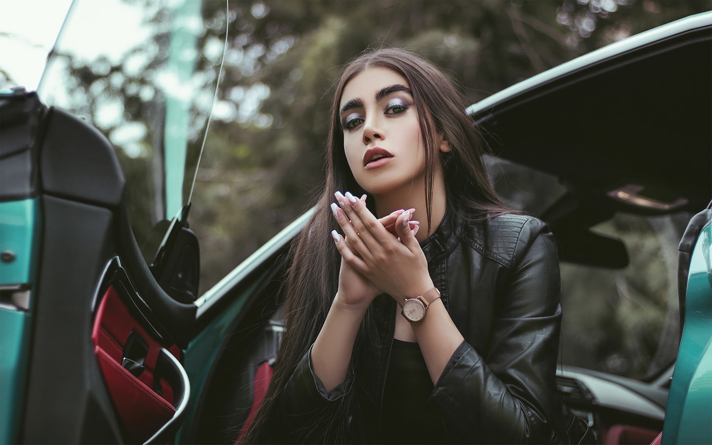 a woman sitting in the back of a green car